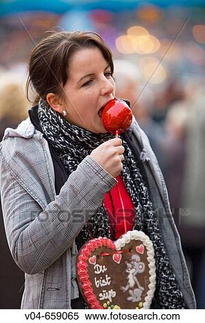 A young woman eating a glaced apple at the Bremen Annual Fair in Germany, Europe View Large Photo Image Stock Photography - A young woman eating a glaced apple at the Bremen Annual Fair in Germany, Europe. Fotosearch