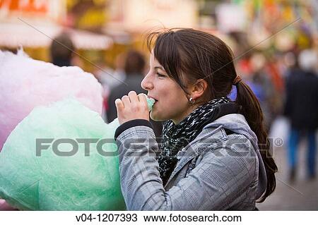 Stock Image - A young woman eating cotton candy at the Bremen Annual Fair, Bremen, Germany, Europe. Fotosearch
