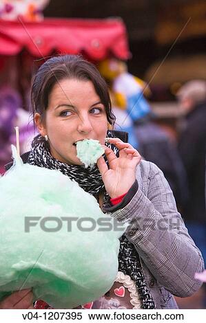 Stock Photography - A young woman eating cotton candy at the Bremen Annual Fair, Bremen, Germany, Europe. Fotosearch