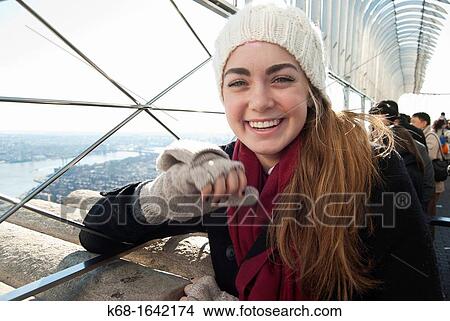 A young woman enjoys the view from the Empire State Building, New York, NY, USA View Large Photo Image Picture - A young woman enjoys the view from the Empire State Building, New York, NY, USA. Fotosearch