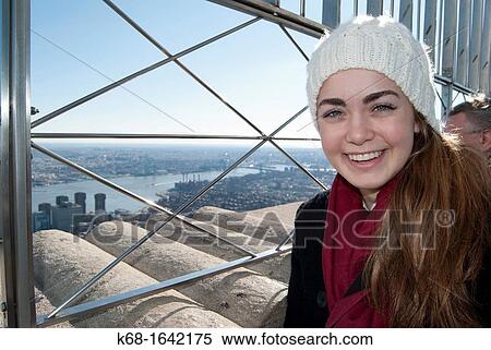 A young woman enjoys the view from the Empire State Building, New York, NY, USA View Large Photo Image Stock Photography - A young woman enjoys the view from the Empire State Building, New York, NY, USA. Fotosearch