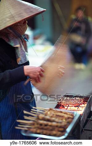 A young woman grilling chicken satay on the street View Large Photo Image Stock Photograph - A young woman grilling chicken satay on the street. Fotosearch