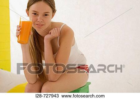 a young woman holding a glass of juice View Large Photo Image Stock Image - a young woman holding a glass of juice. Fotosearch