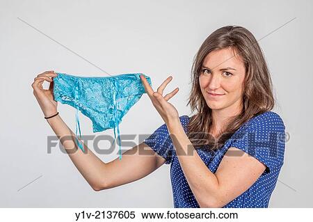 Stock Photography - A young woman holding up a pair of panties.. Fotosearch