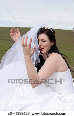 A young woman in a bridal gown, crying in a field. View Large Photo Image Stock Photograph - A young woman in a bridal gown, crying in a field.. Fotosearch
