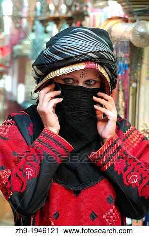 Stock Image - A young woman in a traditional Bedouin dress, Palmyra, Syria.. Fotosearch