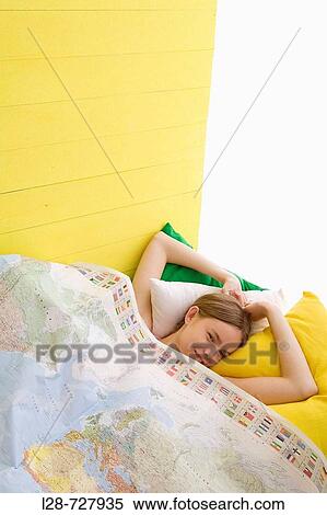 a young woman laying on bed, covering map View Large Photo Image Stock Photography - a young woman laying on bed, covering map. Fotosearch