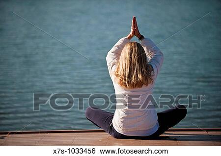 A young woman meditate by a lake View Large Photo Image Stock Photograph - A young woman meditate by a lake. Fotosearch