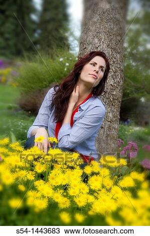 A young woman outdoors in a flower garden View Large Photo Image Stock Image - A young woman outdoors in a flower garden. Fotosearch