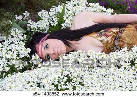 A young woman outdoors in a garden View Large Photo Image Stock Image - A young woman outdoors in a garden. Fotosearch