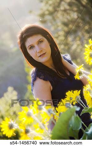 A young woman outdoors in the spring, in a field of Balsamroot flowers. View Large Photo Image Stock Image - A young woman outdoors in the spring, in a field of Balsamroot flowers.. Fotosearch