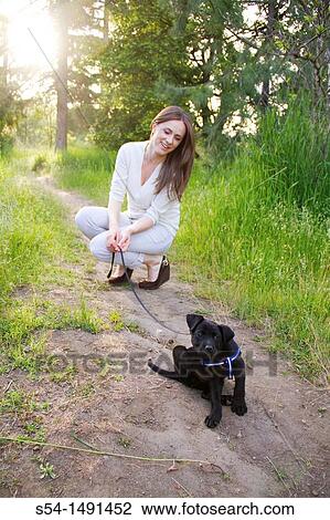 A young woman outdoors with a black lab puppy in Spokane, Washington, USA. View Large Photo Image Stock Image - A young woman outdoors with a black lab puppy in Spokane, Washington, USA.. Fotosearch