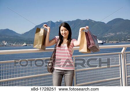A young woman poses with shopping bags at Canada Place, Vancouver, British Columbia, Canada View Large Photo Image Stock Image - A young woman poses with shopping bags at Canada Place, Vancouver, British Columbia, Canada. Fotosearch