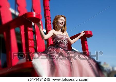 A young woman sitting in a giant red chair. View Large Photo Image Stock Photography - A young woman sitting in a giant red chair.. Fotosearch