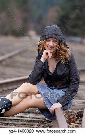 A young woman sitting on train tracks View Large Photo Image Stock Image - A young woman sitting on train tracks. Fotosearch