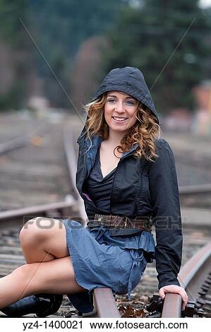 A young woman sitting on train tracks View Large Photo Image Stock Image - A young woman sitting on train tracks. Fotosearch
