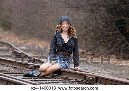 A young woman sitting on train tracks View Large Photo Image Stock Photo - A young woman sitting on train tracks. Fotosearch