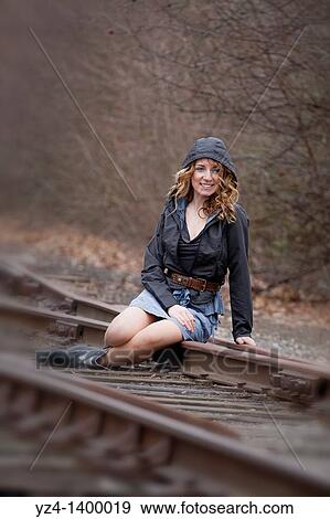 A young woman sitting on train tracks View Large Photo Image Stock Photo - A young woman sitting on train tracks. Fotosearch