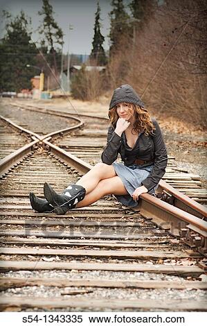 A young woman sitting on train tracks View Large Photo Image Stock Photography - A young woman sitting on train tracks. Fotosearch
