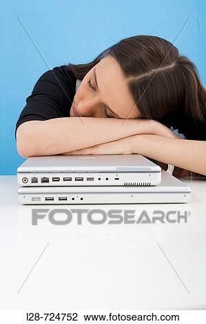 A young woman sleeping at her desk View Large Photo Image Stock Image - A young woman sleeping at her desk. Fotosearch