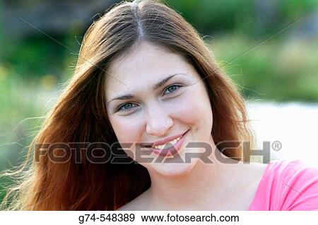A young woman smiling with hair blowing in the wind View Large Photo Image Stock Photo - A young woman smiling with hair blowing in the wind. Fotosearch