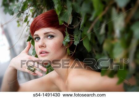 A young woman standing by a climbing plant in Spokane, Washington, USA. View Large Photo Image Stock Image - A young woman standing by a climbing plant in Spokane, Washington, USA.. Fotosearch