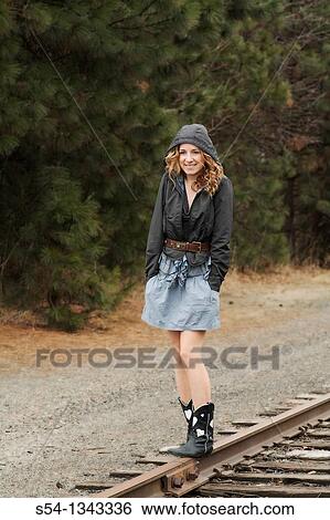 A young woman standing on train tracks View Large Photo Image Stock Photograph - A young woman standing on train tracks. Fotosearch
