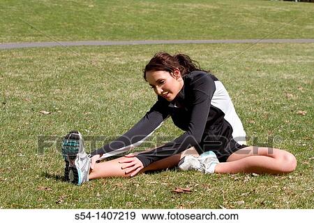 A young woman stretching before exercising View Large Photo Image Stock Photo - A young woman stretching before exercising. Fotosearch