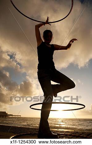 A young woman student at Aberystwyth university using hoolah hoops at sunset, UK View Large Photo Image Stock Image - A young woman student at Aberystwyth university using hoolah hoops at sunset, UK. Fotosearch
