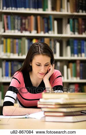A young woman studying in a library View Large Photo Image Picture - A young woman studying in a library. Fotosearch