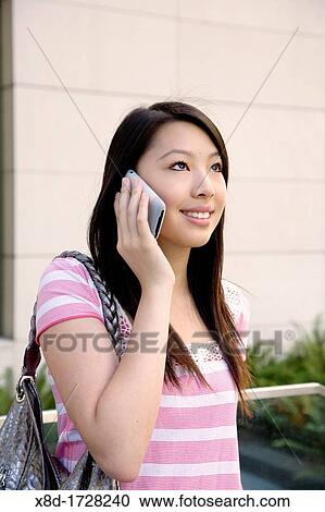A young woman talking on her cell phone View Large Photo Image Stock Image - A young woman talking on her cell phone. Fotosearch