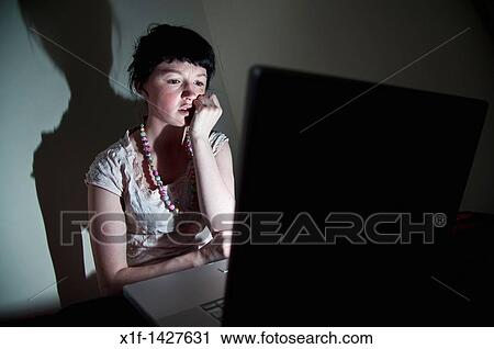 A young woman UK university student working on her laptop computer in her bedroom at home, worried about email virus bug View Large Photo Image Stock Image - A young woman UK university student working on her laptop computer in her bedroom at home, worried about email virus bug. Fotosearch