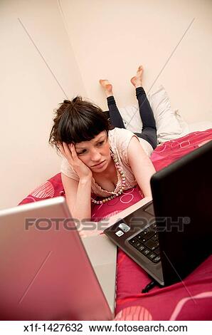 A young woman UK university student working on her laptop computer in her bedroom at home View Large Photo Image Stock Image - A young woman UK university student working on her laptop computer in her bedroom at home. Fotosearch