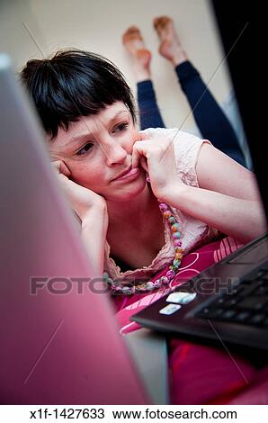 A young woman UK university student working on her laptop computer in her bedroom at home View Large Photo Image Stock Image - A young woman UK university student working on her laptop computer in her bedroom at home. Fotosearch