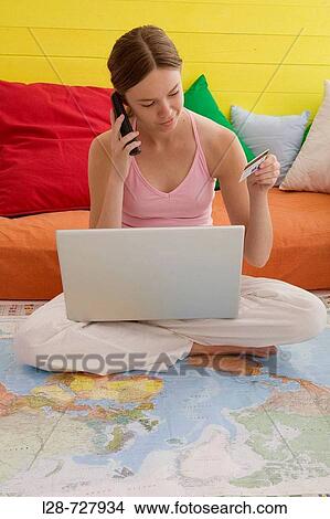 Picture - a young woman using credit card and laptop. Fotosearch