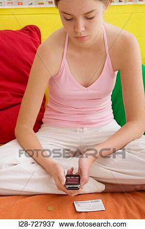 Stock Photo - a young woman using mobile phone. Fotosearch