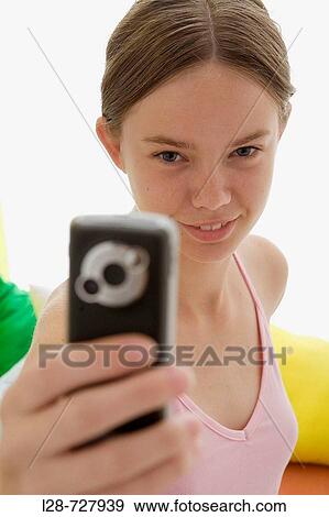 Stock Photo - a young woman using mobile phone. Fotosearch