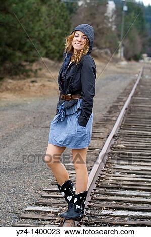 A young woman walking on train tracks View Large Photo Image Stock Image - A young woman walking on train tracks. Fotosearch