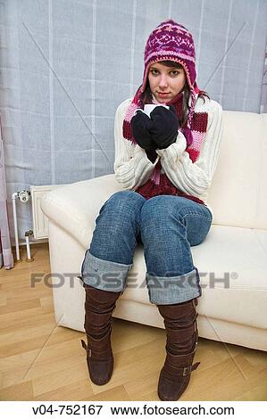 A young woman wearing winter clothes is drinking a hot beverage View Large Photo Image Stock Photo - A young woman wearing winter clothes is drinking a hot beverage. Fotosearch
