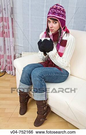 A young woman wearing winter clothes is drinking a hot beverage View Large Photo Image Stock Photograph - A young woman wearing winter clothes is drinking a hot beverage. Fotosearch