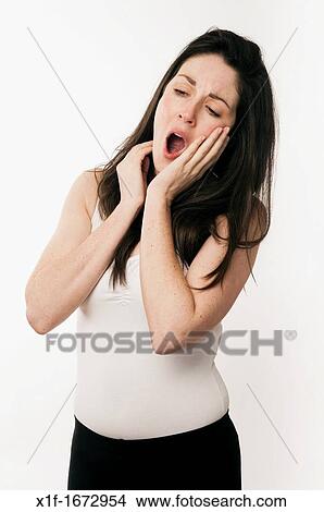 A young woman with brown hair and eyes tired and yawning View Large Photo Image Picture - A young woman with brown hair and eyes tired and yawning. Fotosearch