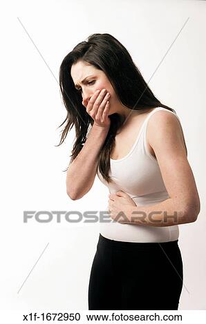 Stock Image - A young woman with brown hair and eyes feeling ill sick nauseous. Fotosearch