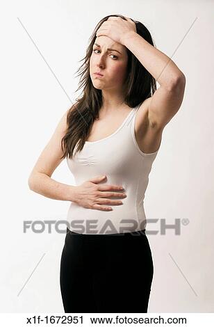 A young woman with brown hair and eyes feeling ill headache and stomach ache pain pains View Large Photo Image Stock Image - A young woman with brown hair and eyes feeling ill headache and stomach ache pain pains. Fotosearch