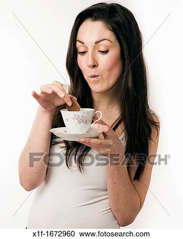 A young woman with brown hair and eyes dunking a chocolate biscuit into a cup of tea View Large Photo Image Stock Image - A young woman with brown hair and eyes dunking a chocolate biscuit into a cup of tea. Fotosearch