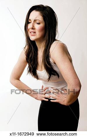 A young woman with brown hair and eyes suffering stomach ache cramps PMT pre menstrual tension View Large Photo Image Stock Photo - A young woman with brown hair and eyes suffering stomach ache cramps PMT pre menstrual tension. Fotosearch