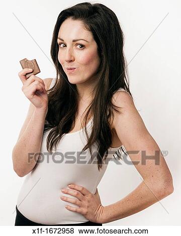 A young woman with brown hair and eyes eating a chocolate biscuit View Large Photo Image Stock Photo - A young woman with brown hair and eyes eating a chocolate biscuit. Fotosearch