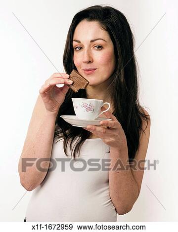 A young woman with brown hair and eyes dunking a chocolate biscuit into a cup of tea View Large Photo Image Stock Photo - A young woman with brown hair and eyes dunking a chocolate biscuit into a cup of tea. Fotosearch