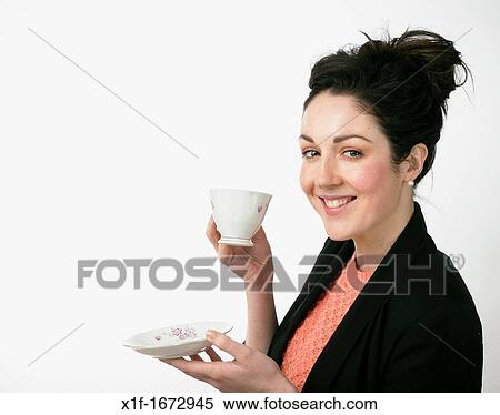 A young woman with brown hair and eyes drinking tea from a dainty cup and saucer View Large Photo Image Stock Photography - A young woman with brown hair and eyes drinking tea from a dainty cup and saucer. Fotosearch