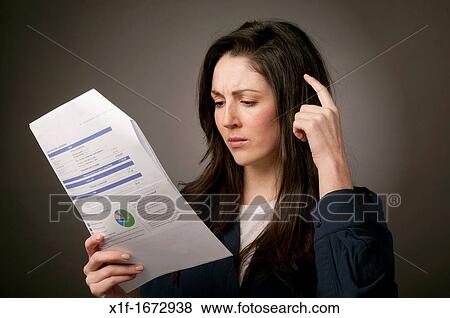 A young woman with brown hair holding her domestic utility heat light water power bills, UK View Large Photo Image Stock Photo - A young woman with brown hair holding her domestic utility heat light water power bills, UK. Fotosearch