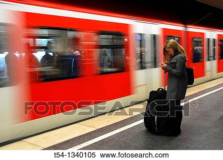 A young woman with luggage, SMS reads as the train enters into the Metro station View Large Photo Image Stock Photography - A young woman with luggage, SMS reads as the train enters into the Metro station. Fotosearch